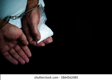 Drug Addict In Handcuffs With A Package Of Drugs In His Hands