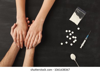Drug Addict Hands Asking For Help On Dark Table With Cooked Heroin, Pills, Spoon And Plastic Bag. Concept Of Addiction And International Day Against Drug Abuse, Top View