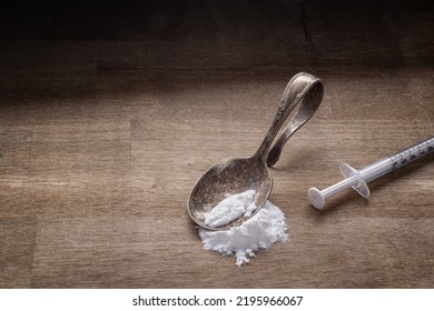 Drug Addiction Concept With Spoon, Syringe And White Powder On Wood