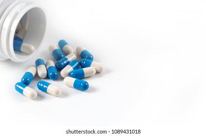 Drug capsule pills with blue  medication in pile, isolated
