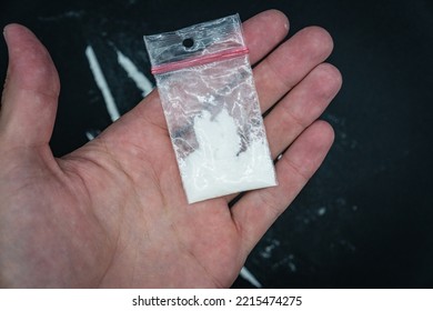 Drug Dealer Holding Bag With Cocaine On Black Background. White Substance In The Bag.