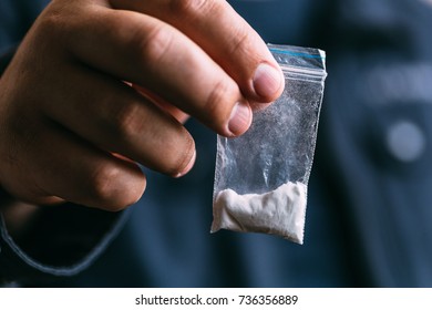 Drug dealer selling drugs junkie. Drug abuse concept and overdose concept. Mans hand holds plastic packet with cocaine powder, selective focus - Shutterstock ID 736356889