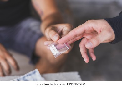 Drug dealer selling ecstasy pills to a drug addict