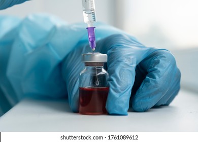 Drug Development Process, A Doctor In A Protective Suit Holds An Ampoule