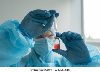 Drug Development Process, A Doctor In A Protective Suit Holds An Ampoule