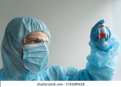 Drug Development Process, A Doctor In A Protective Suit Holds An Ampoule