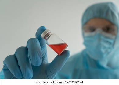 Drug Development Process, A Doctor In A Protective Suit Holds An Ampoule