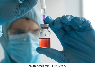 Drug Development Process, A Doctor In A Protective Suit Holds An Ampoule