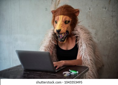 drug selling over the internet. Bad sexy female woman agent with lion mask using laptop computer to trafficking narcotic or heroin. Abuse, Crime, and dope illegal concept against law.