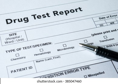 Drug test report form with black pen.