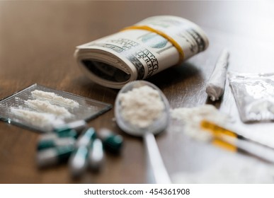 Drug Use, Crime, Addiction And Substance Abuse Concept - Close Up Of Drugs With  Money, Spoon And Syringe