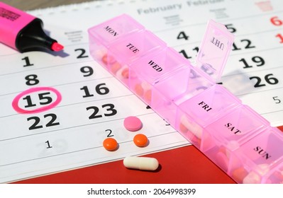 Tabletten aus einer Tablette auf einem Hintergrund eines Kalenders mit einem markierten Datum