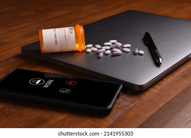 Drugs spilled over a laptop next to a ringing cellphone - Shutterstock ID 2141955303