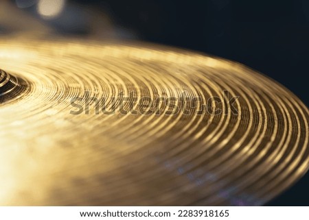 Drum cymbal close-up on a dark background.