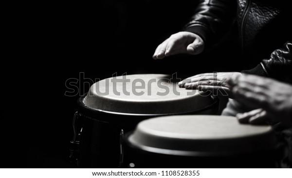 Drum. Hands of a musician
playing on bongs. The musician plays the bongo. Close up of
musician hand playing bongos drums. Afro-Cuba, rum, drummer,
fingers, hand, hit.