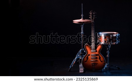 drum kit on stage on a dark background. Set of musical drums and guitars on stage. High quality photo