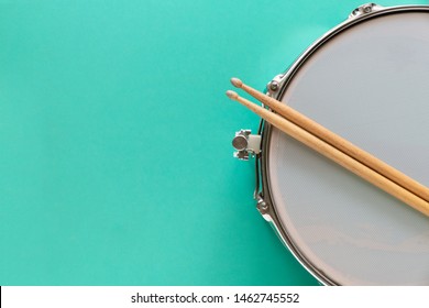 Drum And Drum Stick On Green Table Background, Top View, Music Concept