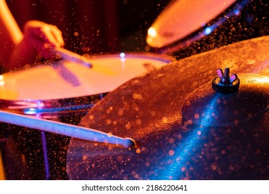 Drum sticks hitting snare drum with splashing water on dark background with orange and blue  studio lighting. Dynamic scene. - Powered by Shutterstock