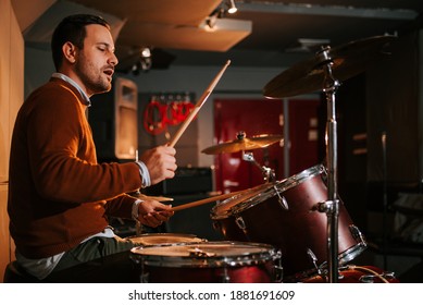 Drummer enjoy playing drums in studio, side view.