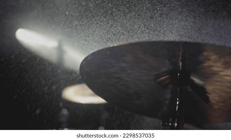 The drummer hits the wet drum cymbal with his drumstick and the water splashes in slow motion. In the recording studio of musical instruments. Knocks and beats, Repetition of rock music band. - Powered by Shutterstock