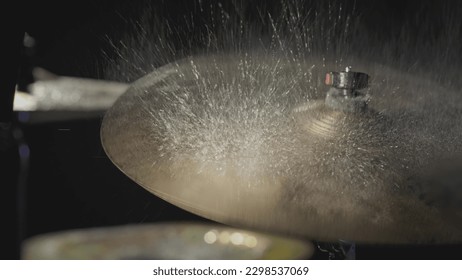 The drummer hits the wet drum cymbal with his drumstick and the water splashes in slow motion. In the recording studio of musical instruments. Knocks and beats, Repetition of rock music band. - Powered by Shutterstock