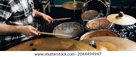 The drummer knocks on the drum set.