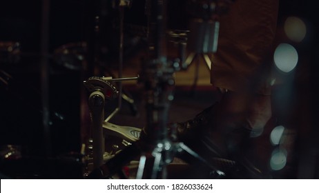 Drummer man leg pressing pedal on bass drum in concert hall. Closeup drum pedal in action in sound recording studio. Unrecognizable drummer using drum set indoor. - Powered by Shutterstock