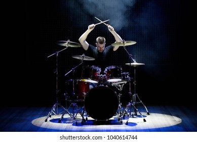 Drummer playing the drums with smoke and powder in the background