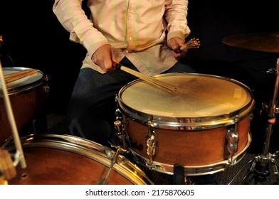 A Drummer Is Playing A Natural Wood Colour Snare Drum With Sticks And Brushes Under Warm Soft Mood Light (vintage Retro Style)