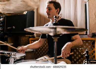 Drummer rehearsing on drums before rock concert. Man recording music on drum set in studio