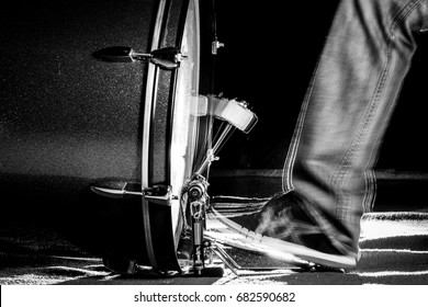 The drummer's foot wears sneaker is playing bass drum pedal in low light background, black and white - Powered by Shutterstock