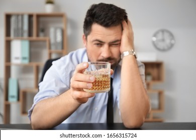 Ein betrunkener Geschäftsmann mit einem Glas Whiskey im Büro. Alkoholismus