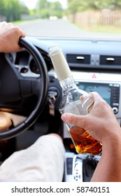 Drunk driver on a rural road with a bottle of alcohol in hand