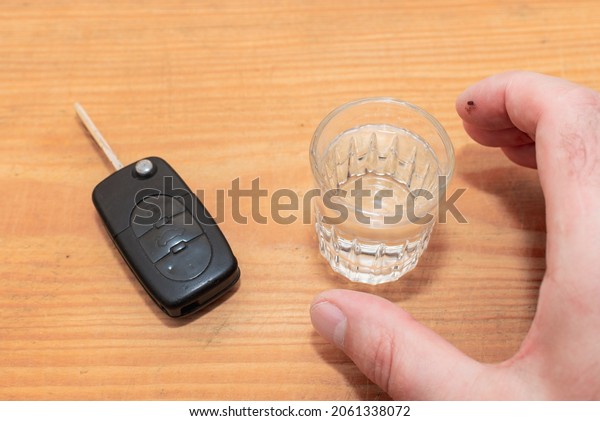 Drunk driving -\
the cause of car accidents. Hand reaches for car key and\
alcohol.Drink. Male hands and auto\
keys.