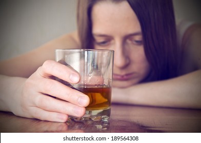 drunk girl holding a glass with alcohol