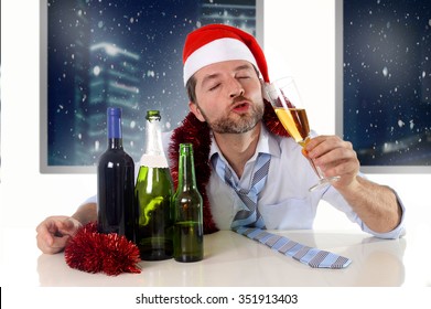 Drunk Happy Business Man In Santa Hat With Alcohol Bottles In New Year Toast With Champagne Glass Smiling Drinking Too Much At Christmas Party At Night In The Office