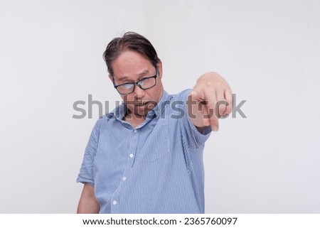 A drunk and inebriated middle aged man pointing to the camera while slurring his speech. Isolated on a white backdrop.