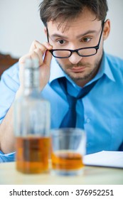 Drunk man drinking alcohol while working  