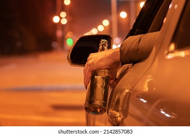 Drunk Man Driving A Car With A Bottle Of Beer At The Night. Don't Drink And Drive Concept.