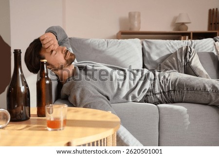 Drunk man lying on sofa. Alcoholism concept