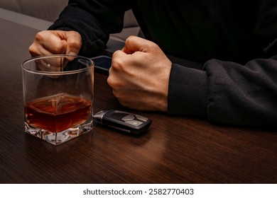 

Drunk man lying on the table with a glass of alcohol, car keys on the counter, drunk car driver, drowning sadness in a glass of whiskey, despair