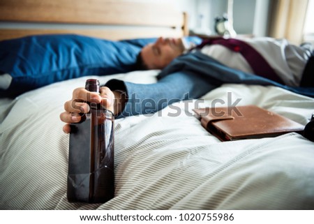 A drunk man passing out in bed