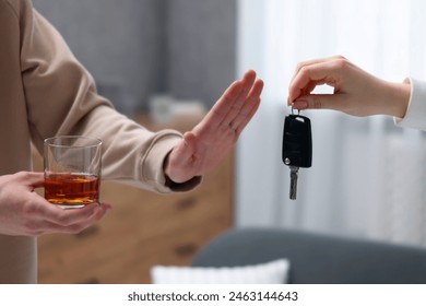 Drunk man refusing drive car while woman suggesting him keys, closeup. Don't drink and drive concept