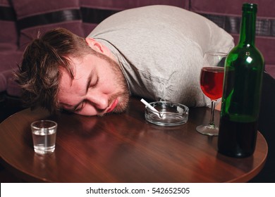Drunk man sleep on wooden table.