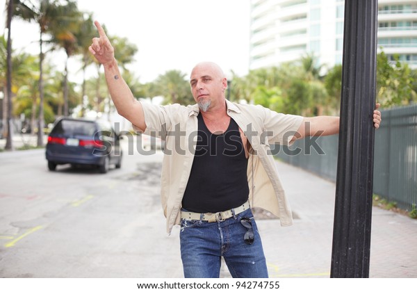 Drunk man waving at cars\
passing by