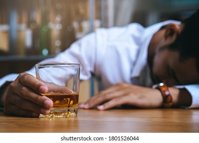 Drunk person sleep at bar have a alcohol drink in hands
