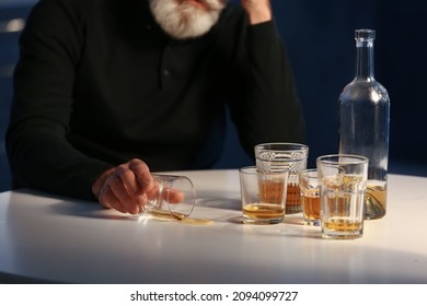 Drunk Senior Man With Glass Of Drink In Kitchen At Night