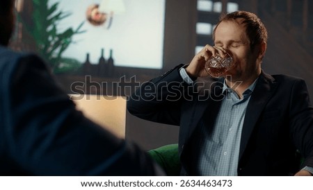 Drunk upper class elite society member being loud and obnoxious at the social club, embarrassing himself due to alcohol intoxication. Gentlemen in a state of euphoria after whiskey drinks. Camera B.