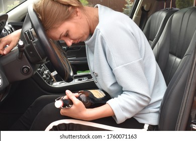 drunk woman with a bottle of alcohol in a car. Driving while intoxicated. danger of an accident on the road. Drinking abuse. alcohol addiction while driving. - Powered by Shutterstock