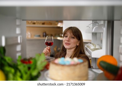 Drunk Woman With A Glass Of Red Wine Chooses Food In The Fridge